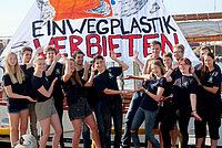 14 junge Menschen vor einem Banner mit der Aufschrift: Einwegplastik verbieten.